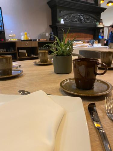 una mesa con una taza de café encima en Hôtel Au Château, en Villers-lès-Nancy