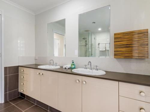 a bathroom with two sinks and a large mirror at Luxury 5BR Retreat Family house with Pool in GC in Gold Coast