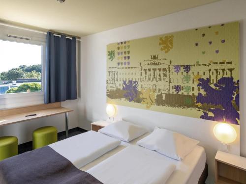 um quarto de hotel com uma cama e um quadro na parede em B&B Hotel Braunschweig-Nord em Braunschweig