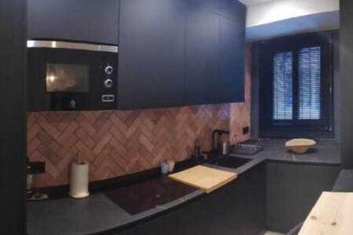 een keuken met een wastafel en een magnetron bij Alameda 2 Dormitorios in Sevilla