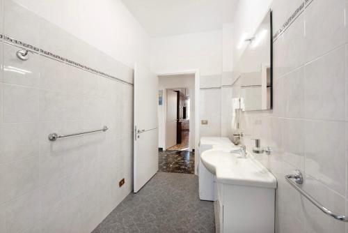 ein weißes Badezimmer mit einem Waschbecken und einem Spiegel in der Unterkunft Il Gabbiano in Albissola Marina