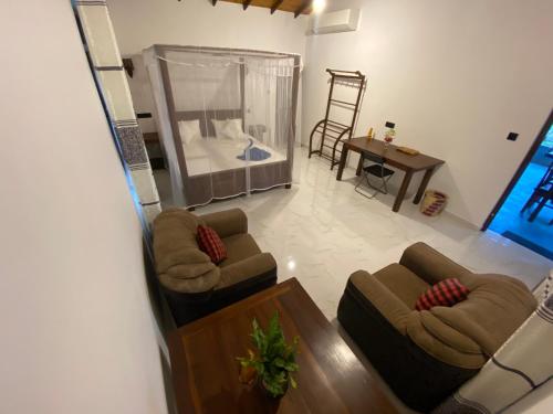 a living room with two couches and a bed at See Turtle Villa in Tangalle
