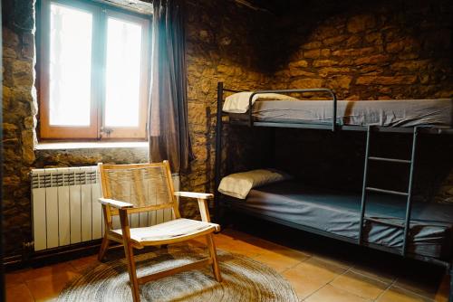 una sedia a dondolo in una camera con letto a castello di Cases Altes de Posada a Navés