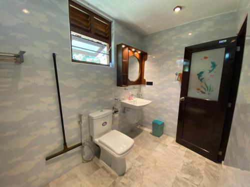 a bathroom with a toilet and a sink and a window at See Turtle Villa in Tangalle