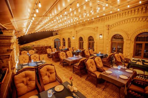 HOTEL SILK ROAD EMPIRE SAMARKAND في سمرقند: مطعم فيه طاولات وكراسي في الغرفة