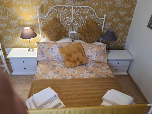 a bedroom with a bed with pillows and two lamps at Villa Feliza in Güime