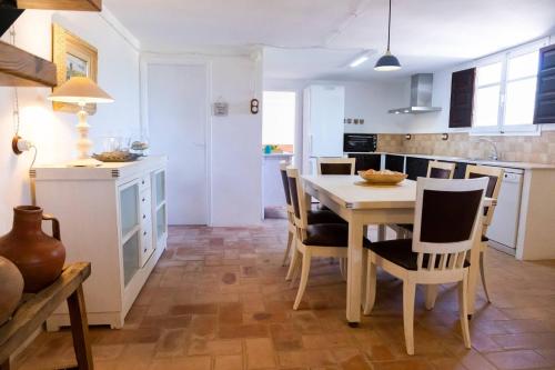 a kitchen and dining room with a table and chairs at Santolina - Casa Rural en l'Ampolla con piscina privada, jardín y barbacoa - Deltavacaciones in L'Ampolla