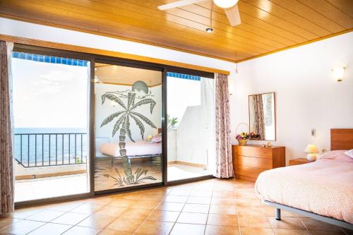 ein Schlafzimmer mit einem Bett und einem Balkon in der Unterkunft Mistral - Adosado en l'Ampolla con acceso directo al mar - Deltavacaciones in L'Ampolla
