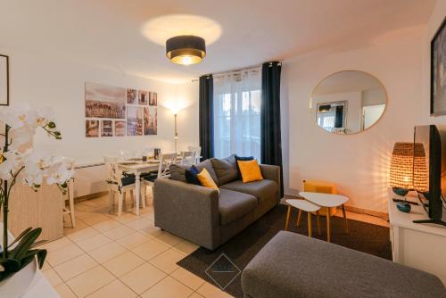 un salon avec un canapé et une salle à manger dans l'établissement Disneyland Résidence Bmyguest, à Serris