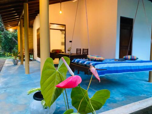 a room with a bed and a plant with a flower at See Turtle Villa in Tangalle