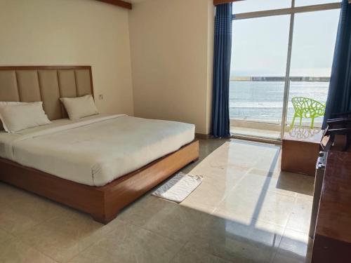 a bedroom with a bed with a view of the ocean at Hotel Sea Moon in Cox's Bazar