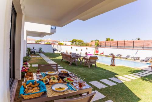 un tavolo con cibo su un patio accanto alla piscina di JULİETOTEL ad Alaçatı