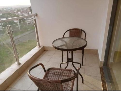a balcony with two chairs and a table and a window at Ngao property in Nairobi