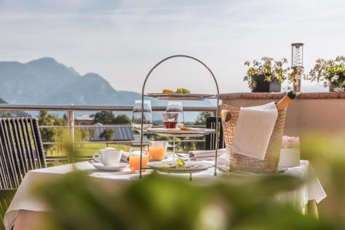 a table with food and drinks on a balcony at SOLEA DOLOMITI Boutique Hotel in Fai della Paganella