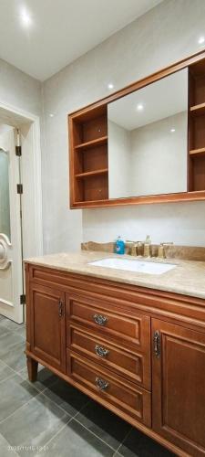 a bathroom with a sink and a large mirror at Spacious Villa with Garden & Parking 6 Mins to Station in Harrow