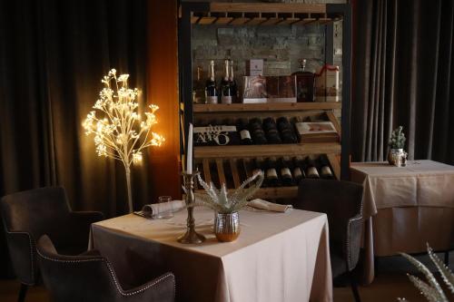 a dining room with two tables and a shelf of wine bottles at SOLEA DOLOMITI Boutique Hotel in Fai della Paganella