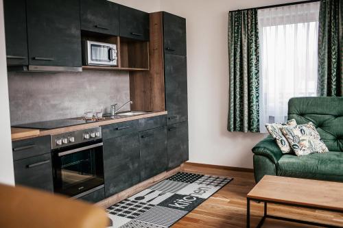 salon z kuchnią i kanapą w obiekcie Alpenhotel & Aparthotel Lanz w mieście Hohentauern