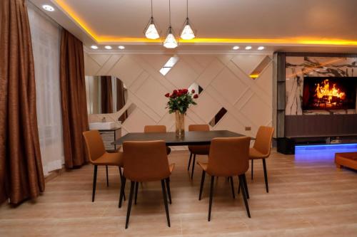 a dining room with a table and chairs and a fireplace at Lux Suites Nakuru VIP Suites on FULL BOARD in Nakuru