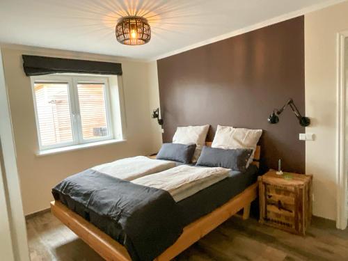 una camera da letto con un letto con una lampada e una finestra di Ferienwohnung „Klüterkamer“ - Hof Mühlenkoppel a Hasselberg