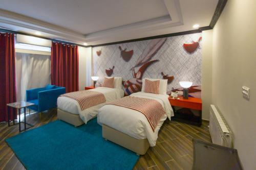 a hotel room with two beds and a blue rug at The Vibe By Ambiance in Murree