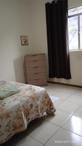 1 dormitorio con 1 cama, vestidor y ventana en Quarto individual com cama de casal, en Mariana