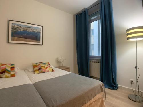 カンヌにあるAppartement Clemenceauのベッドルーム1室(青いカーテン、窓付)