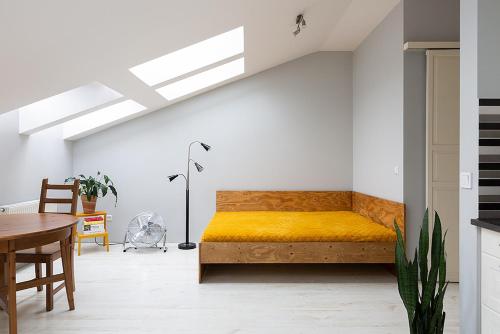een slaapkamer met een geel bed en een tafel bij Sunny Studio Mostowa Krakow Kazimierz by Renters in Krakau