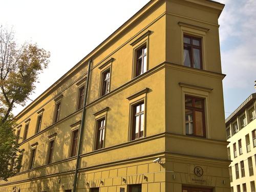 een geel gebouw met een klokkentoren erop bij Sunny Studio Mostowa Krakow Kazimierz by Renters in Krakau