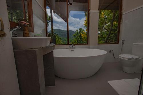 a bathroom with a tub and a sink and a toilet at Serenite Ella in Ella