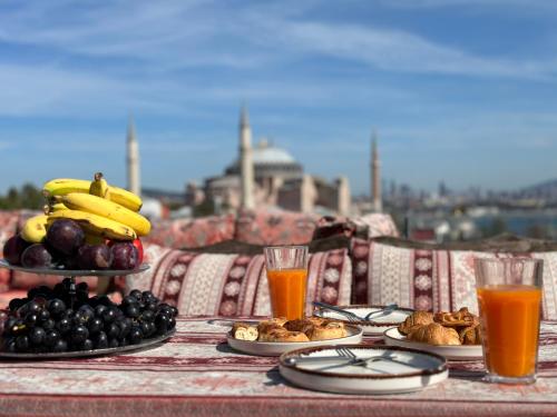 a table topped with plates of fruit and juice at World Heritage Center Hotel in Istanbul
