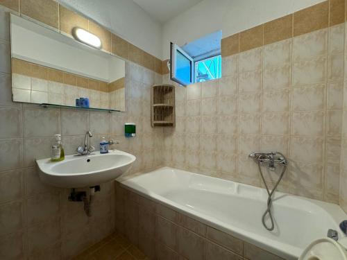 a bathroom with a sink and a bath tub and a sink at Garden Paradise in Megalochori Trikala in Tríkala