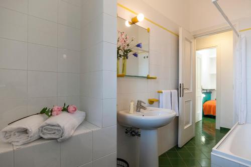 ein weißes Badezimmer mit einem Waschbecken und einem Spiegel in der Unterkunft Casa Vacanza Kair Trilo 263 in Sperlonga