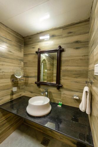 a bathroom with a sink and a mirror at Saavaj Resort, Sasan Gir - Where Wilderness Meets Luxury in Sasan Gir