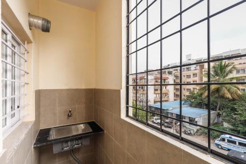 a bathroom with a sink and a large window at Elite Peak Serviced Apartments in Bangalore