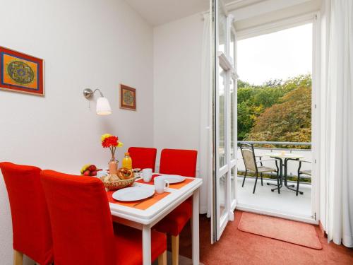 una sala da pranzo con tavolo e sedie e un balcone di Apartment Zinnowitzer Hof-3 by Interhome a Zinnowitz