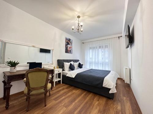 Schlafzimmer mit einem Bett, einem Schreibtisch und einem Stuhl in der Unterkunft Cozy Apartments at Maurer Residence Brasov in Braşov