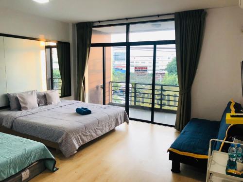 バンコクにあるSleepy and Homey Don Mueang Airport Hostelのベッドルーム1室(ベッド1台付)が備わります。バルコニーの景色を望めます。