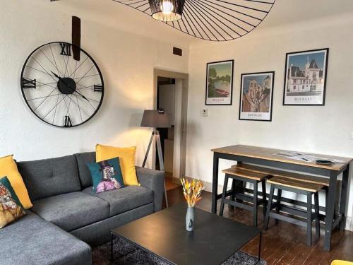 un salon avec un canapé et une horloge au mur dans l'établissement 4 Pièces, 70m² en centre-ville, à Bourges