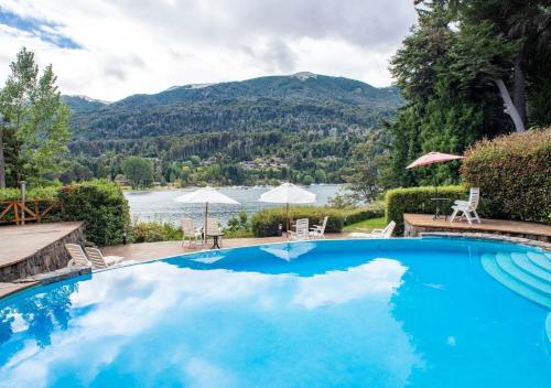 una piscina con vistas al lago y a las montañas en El Muelle by DOT Boutique en Villa La Angostura