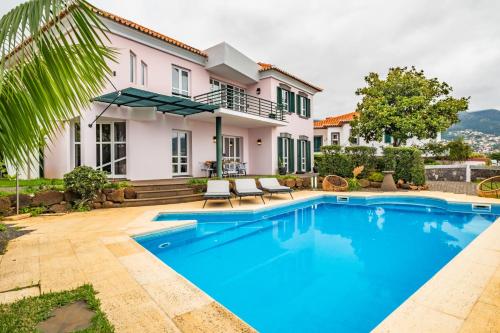 a villa with a swimming pool in front of a house at Villa Magnólia in Funchal