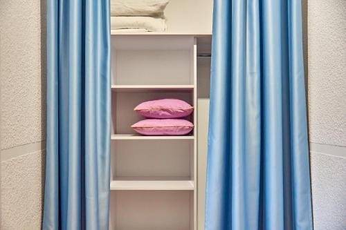 a closet with blue curtains and pink pillows at Best Apartments on Kyryla & Mefodia in Mukacheve