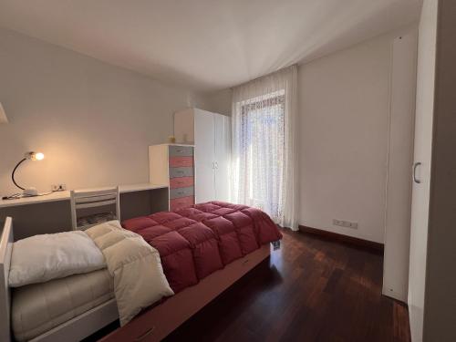 ein Schlafzimmer mit einem großen Bett mit einer roten Decke in der Unterkunft 008 Quadrilocale, Pinzolo in Pinzolo