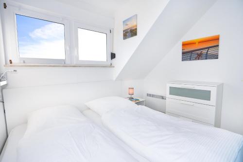 - une chambre blanche avec un lit et une fenêtre dans l'établissement Glücksmoment Grömitz, à Grömitz