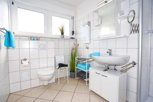 La salle de bains blanche est pourvue d'un lavabo et de toilettes. dans l'établissement Glücksmoment Grömitz, à Grömitz