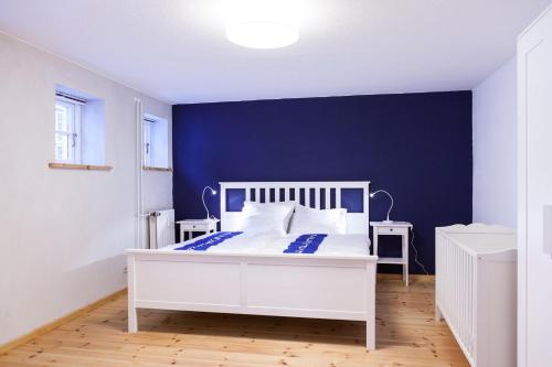 um quarto com uma cama branca e uma parede azul em Beim Museumshafen em Flensburg
