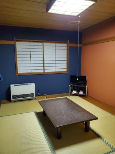 a living room with a table in the middle of a room at Matsupokkuri in Zaō Onsen