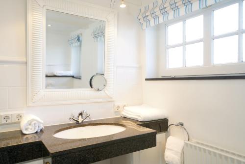 a bathroom with a sink and a mirror at Strandhaus Falshöft 3 in Nieby