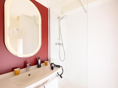 a bathroom with a sink and a shower at ibis Valenciennes in Valenciennes