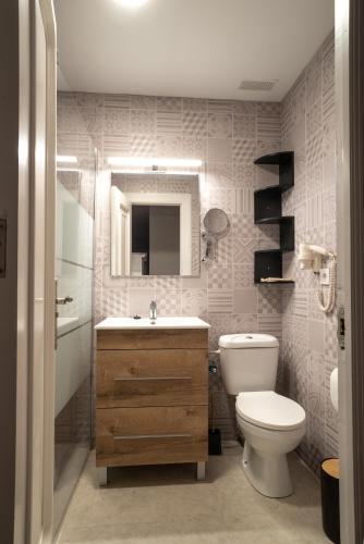 a bathroom with a toilet and a sink and a mirror at Apartamento Pinbal in Haro
