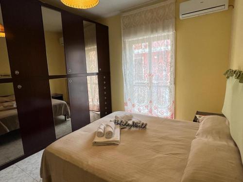 een slaapkamer met een bed met schoenen en een spiegel bij La Baia Di Tindari by Holiday World in Oliveri